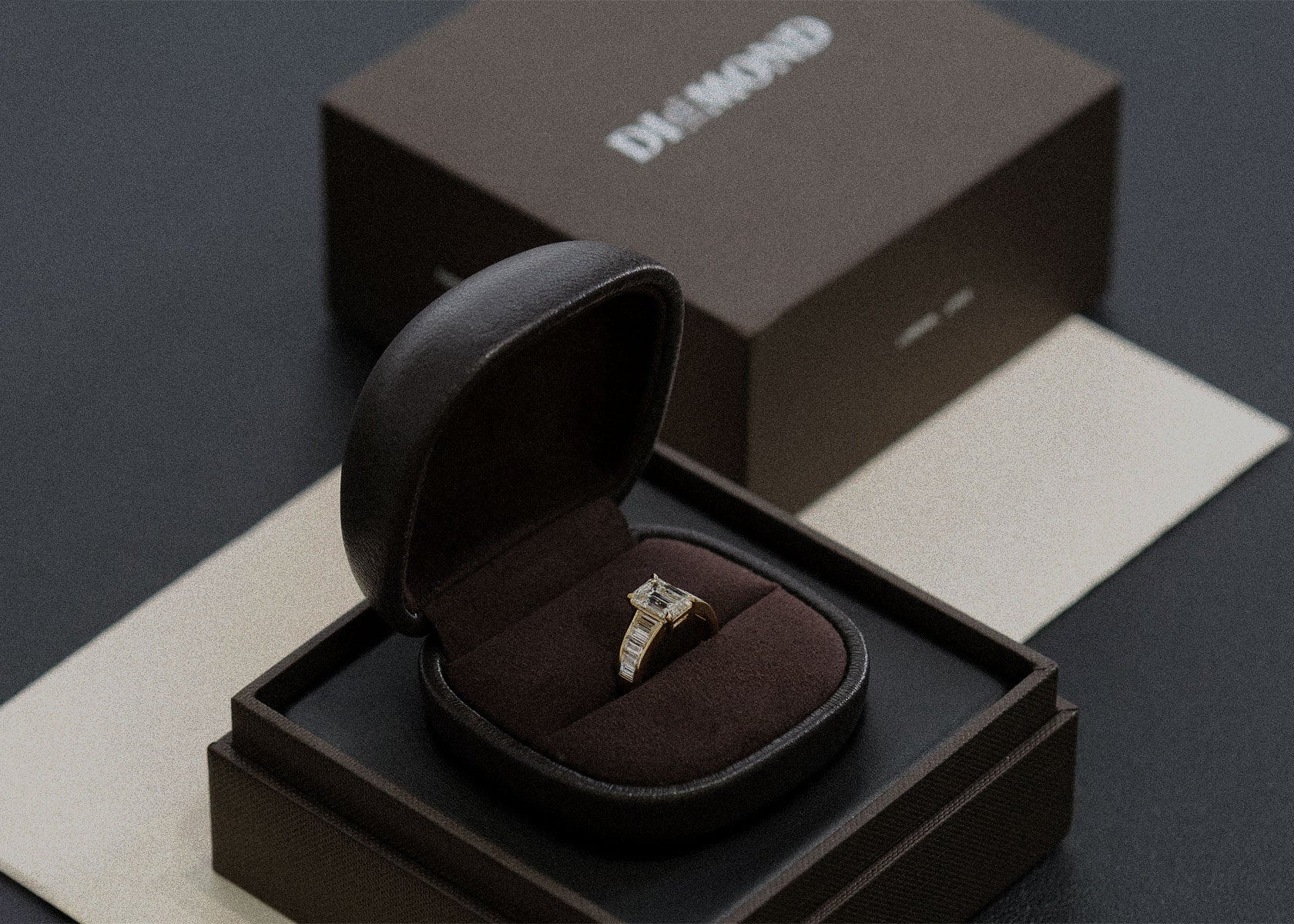 Diamond ring in a black box on a dark surface